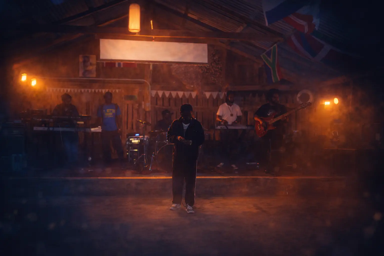 A crowd enjoying live music at a beachfront rustic bar